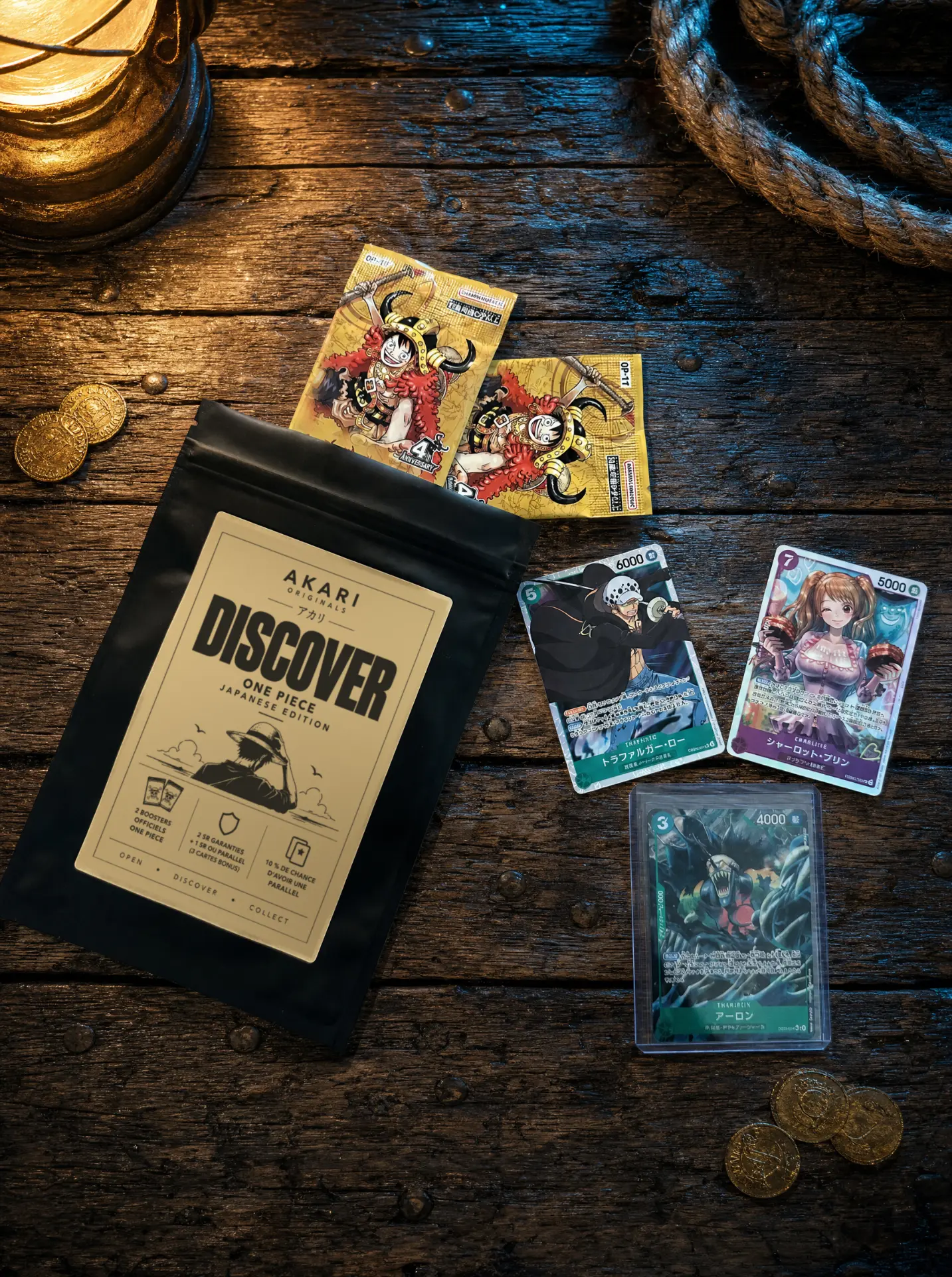 Sachet Akari Discover One Piece avec deux boosters officiels japonais et trois cartes (Trafalgar Law, Charlotte Pudding, Arlong en toploader), devant une lanterne allumée